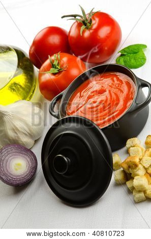 Soupe de tomate dans une casserole noire et ingrédients