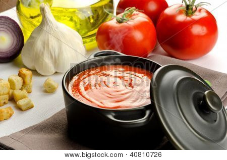 Soupe de tomate dans une casserole noire et ingrédients