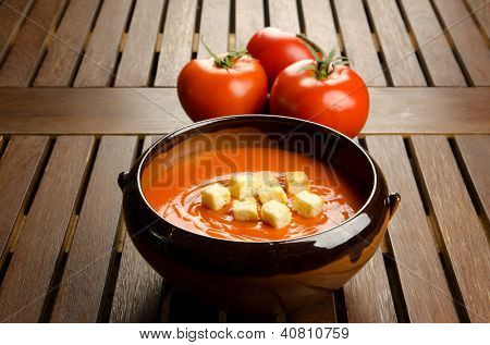 Tomatsuppe i en fajance skål med tomater