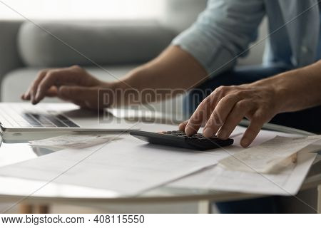 Man Bookkeeper Working With Bills Pay Taxes Online Using Laptop