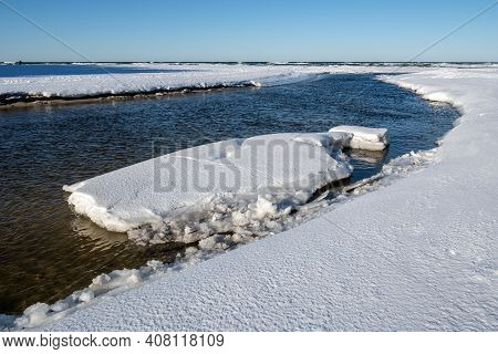 River Bank Covered With Snow. The Mouth Of The Pasnica River Into The Baltic Sea During Winter. Debk