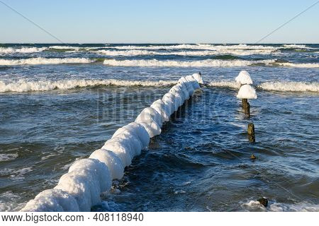 Snow Caps On Wooden Stakes At The Baltic Sea During Winter. Debki, Poland