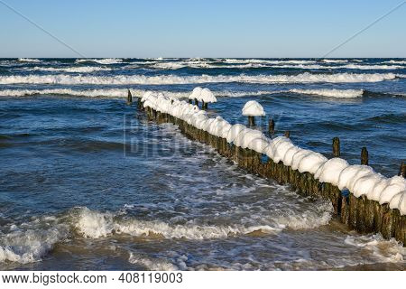 Snow Caps On Wooden Stakes At The Baltic Sea During Winter. Debki, Poland