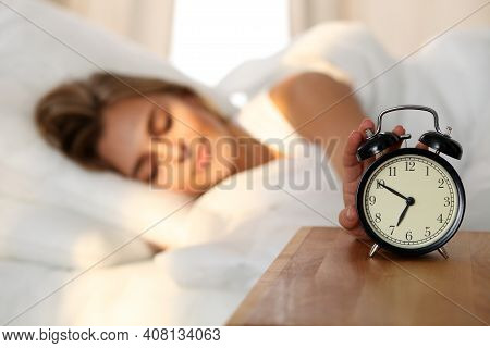 Sleepy Young Woman Stretching Hand To Ringing Alarm Willing Turn It Off. Early Wake Up, Not Getting 