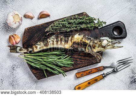 Cooked Mackerel Icefish On A Wooden Cutting Board. Black Background. Top View
