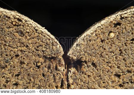 Two Slices Of Freshly Baked Borodino Bread With Spices On A Black Background Closeup