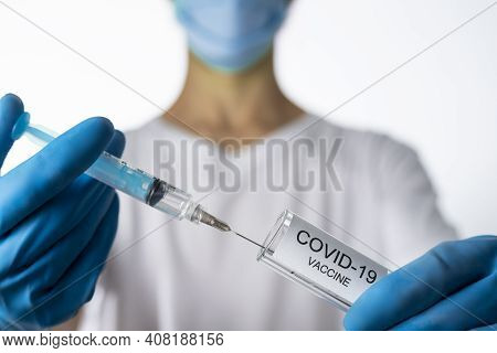Doctor Filling Syringe With Coronavirus Covid-19 Vaccine. On White Background