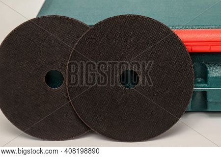 Abrasive Black Wheel, Grinding Wheel On The Background Of The Green Toolbox. Abrasive Materials, Dis