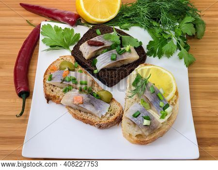 Different Open Sandwiches Made With Slices Of Pickled Herring Fillet And Various Bread Kinds On A Sq