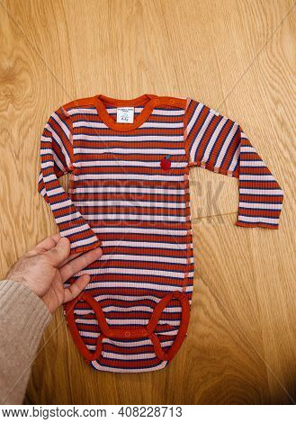 Paris, France - Feb 14, 2021: Male Hand Holding New Baby Body Manufactured By Swedish Company Polarn
