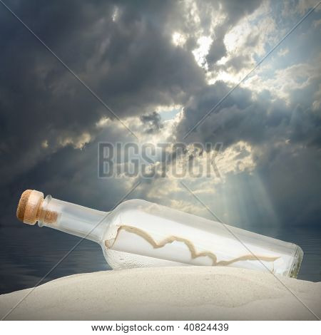 Flaske med en besked mod dramatisk himmel.