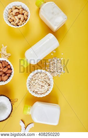 Alternative Types Of Vegan Milks In Bottles On A Yellow Background