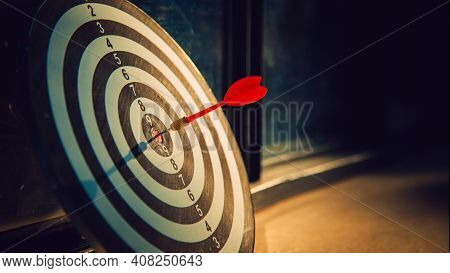 Dart Arrow Hit On Bulleyes Of Dartboard To Represent That The Business Reached The Target  With Dark