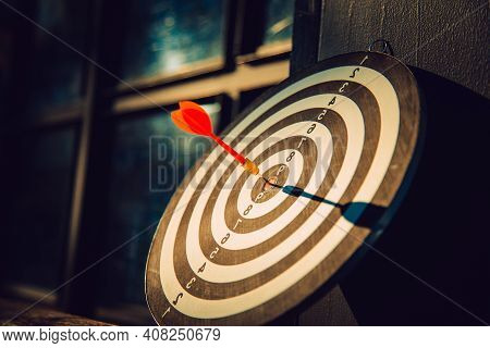 Dart Arrow Hit On Bulleyes Of Dartboard To Represent That The Business Reached The Target  With Dark