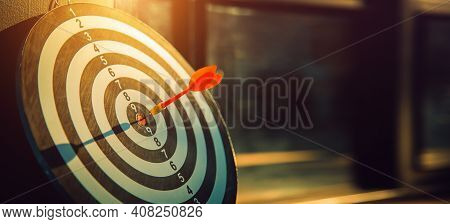 Dart Arrow Hit On Bulleyes Of Dartboard To Represent That The Business Reached The Target  With Dark