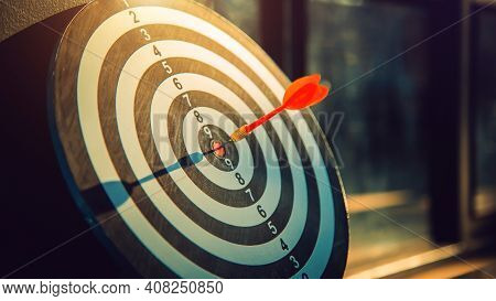 Dart Arrow Hit On Bulleyes Of Dartboard To Represent That The Business Reached The Target  With Dark