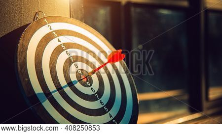 Dart Arrow Hit On Bulleyes Of Dartboard To Represent That The Business Reached The Target  With Dark