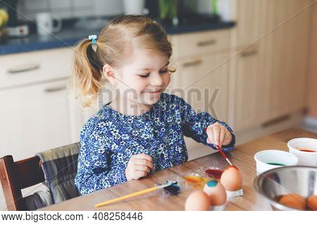 Excited Little Toddler Girl Coloring Eggs For Easter. Cute Happy Child Looking Surprised At Colorful