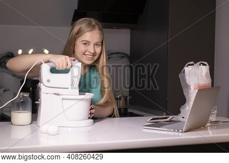 A Blonde Woman Chef Videoblogger Cooking In The Kitchen And Filming, Online Learning Or Remote Cooki
