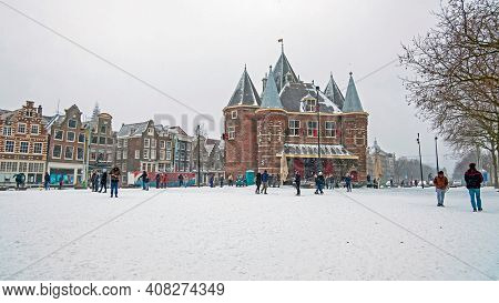 Traditional snowy Waag building at the Nieuwmarkt in Amsterdam in the Netherlands in winter