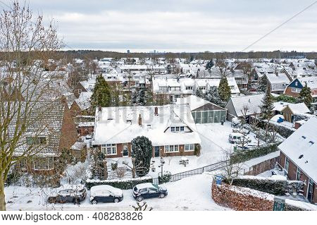 Aerial from snowy town Huizen in the Netherlands in winter