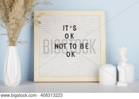 Dried Pampas Grass In Vases, Candles And Felt Letter Board With Phrase It Is Ok Not To Be Ok On Blue