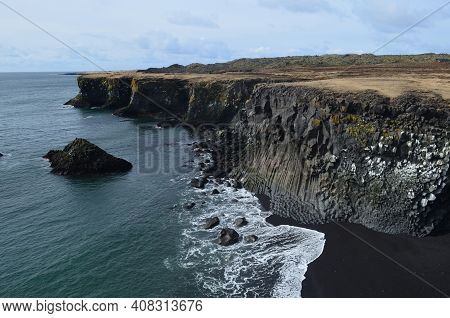 Waves On The Black Sand Beach With Basalt Columns.