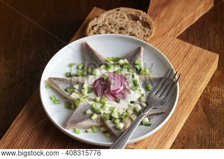 Herrings Fillets With Cream Sauce With Cucumbers, Red Onion And On Cutting Wooden Board