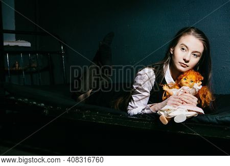 pretty girl with an old doll in an abandoned building