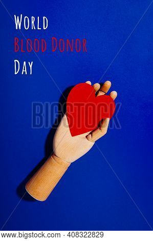 Wooden Hand With Big Red Heart In A Giving Gesture. World Blood Donor Day Wording. Donation, Help, H