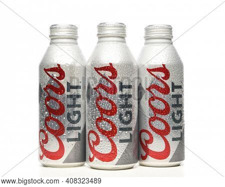 IRVINE, CALIFORNIA - APRIL 15, 22019: Three Coors Light Aluminum Pint Bottles with condensation on white with reflection.