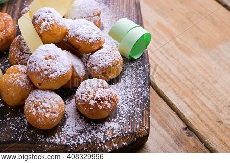 Baked Castagnole With Powdered Sugar And Confetti On A Wooden Table. Round Biscuits With Sugar For T