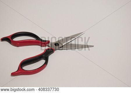 One Kitchen Scissor With Black And Red Plastic Handle Isolated On White Background