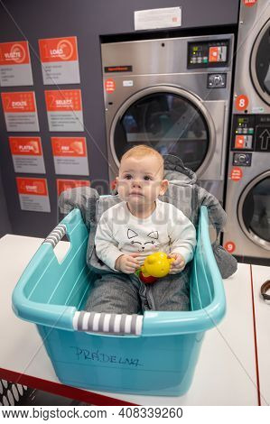 Prague, Czech Republic - 16.12.2020: Baby Girl In The Plastic Basket Waiting In Laundry Room With Sp