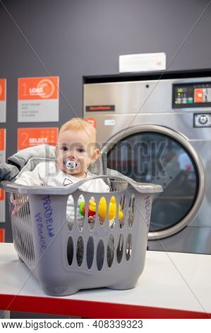 Prague, Czech Republic - 16.12.2020: Baby Girl In The Plastic Basket Waiting In Laundry Room With Sp