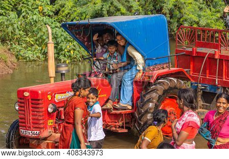 Agalkera, Karnataka, India - November 9, 2013: Happy Dad With Little Kids On Red Mahindra Tractor Wi
