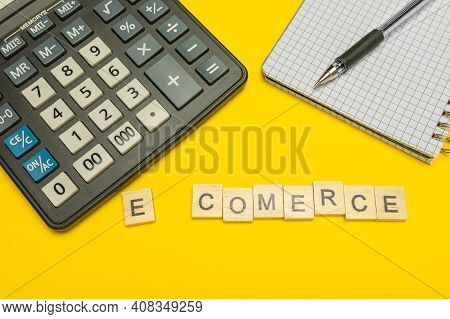 Word E-comerce Made With Wood Letters On Yellow Background And Modern Calculator With Pen And Notebo