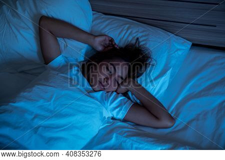 Top View Of Beautiful Young Woman Sleeping Cozily On A Bed In His Bedroom At Night. Blue Nightly Col