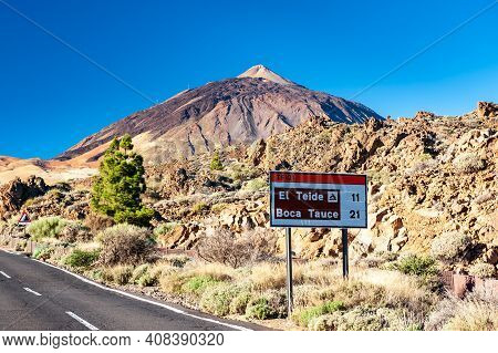 Silhouette Of Volcano Del Teide And Signpost Against  Blue Sky. Pico Del Teide Mountain In El Teide 