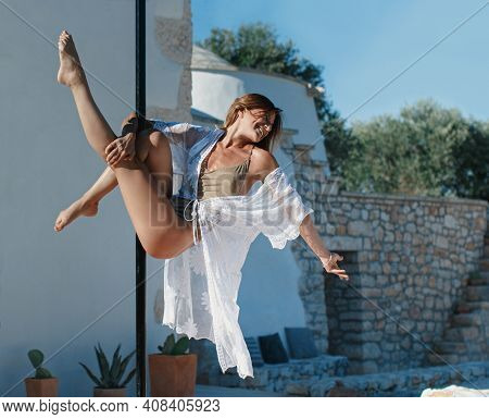 Young Pole Dancer Posing On A Portable Platform Against The Villa Wall.  Athletic Caucasian Woman Tr