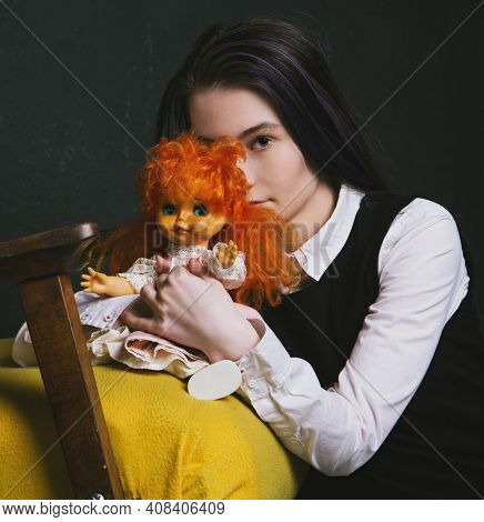 pretty girl with an old doll in an abandoned building