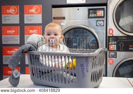 Prague, Czech Republic - 16.12.2020: Baby Girl In The Plastic Basket Waiting In Laundry Room With Sp