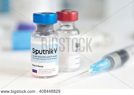 The Vaccine Sputnik V From The Coronovirus Infection Covid 19 On A Blue Background And A Syringe On 