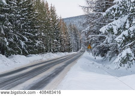 Asphalt Road In Winter, In The Jizera Mountains.\njizera Mountains In Poland. Asphalt Road Covered W