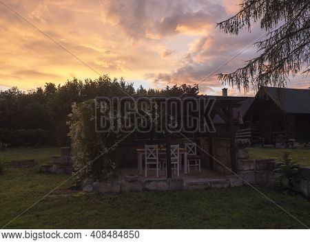 View Of Summer Garden With Tiber Wooden Gazebo Pergola With Blooming Climbing Plant Flowers And Whit