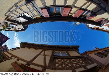 Fisheye View Of The Sky Above A Narrow Street In Riquewihr Town, Alsace, France
