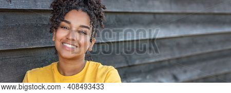 Panorama girl teenager teen female young African American mixed race biracial woman outside smiling with perfect teeth panoramic header web banner