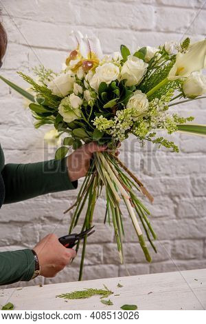 The Florist Creates A Floral Arrangement Of Roses, Lilacs, Callas, Carnations, Hydrangeas, Brasica,