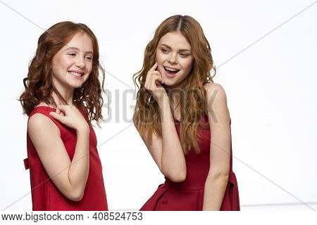 Cheerful Mom And Daughter Next To Red Dresses Hugs Lifestyle Light Background Smile