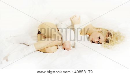 kaunis blondi tyttö makaa sängyssä
